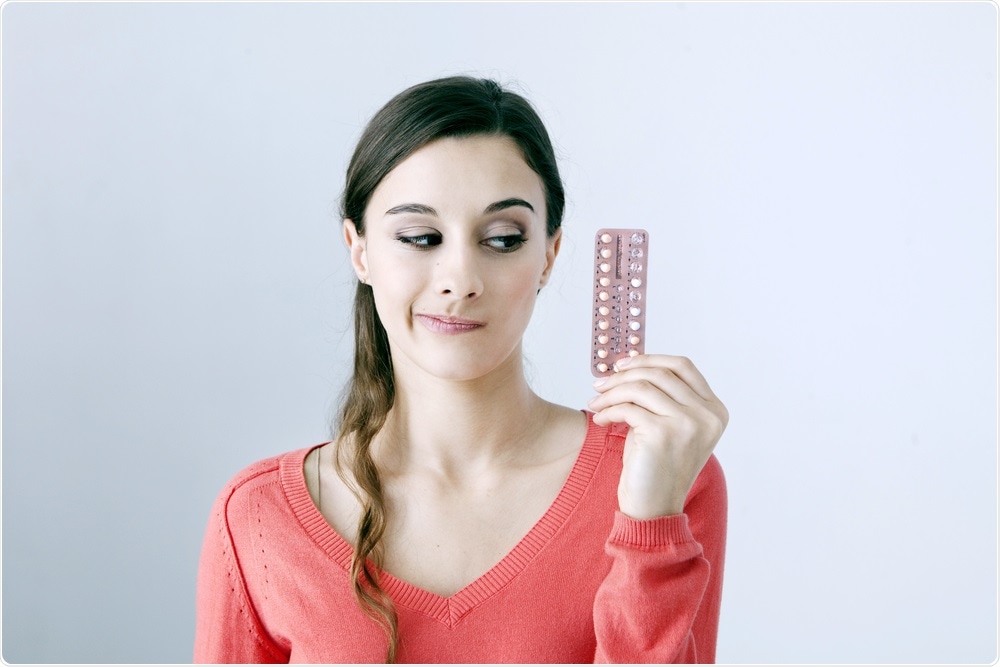 Woman holding the contraceptive pill