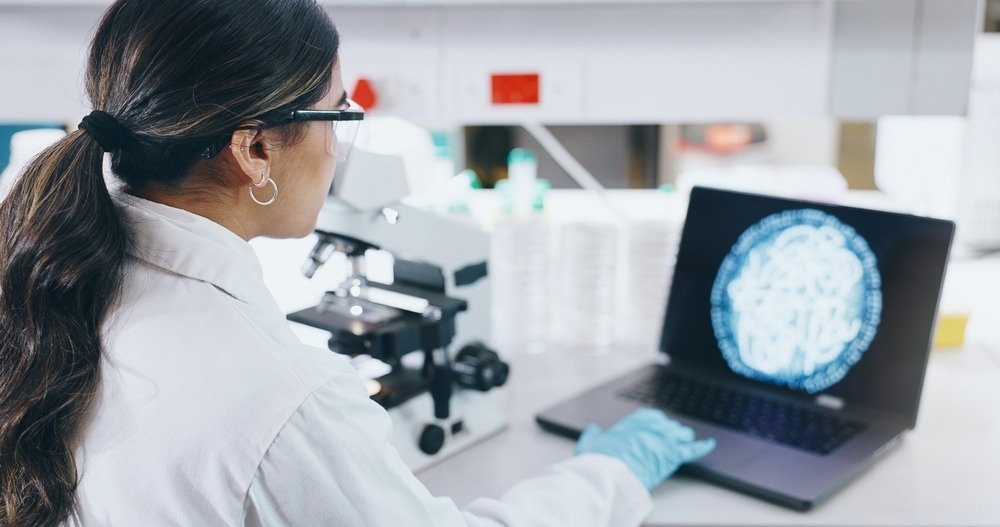 Woman scientist and laptop with microscope in lab.