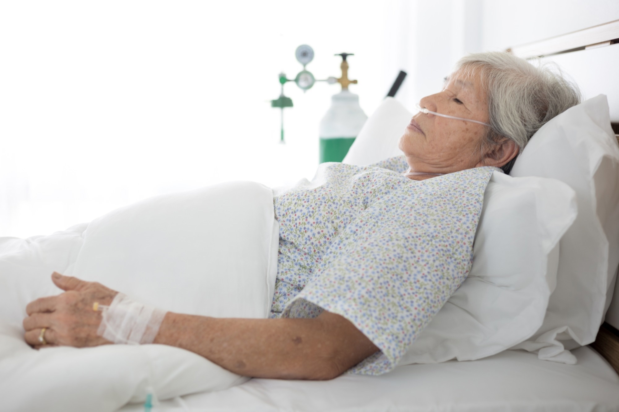 Elderly patient wear oxygen cannula in hospital bed