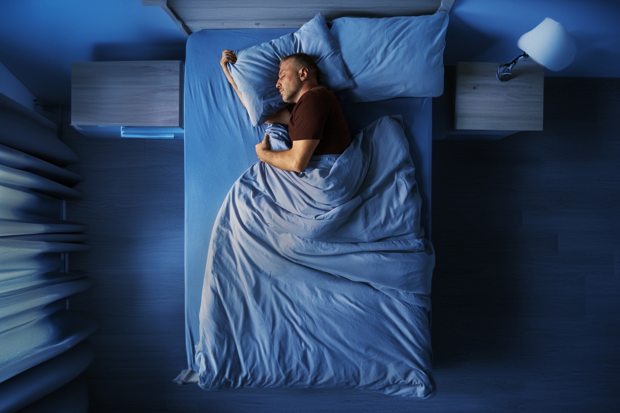 Top view of single middle aged man peacefully sleeping alone in bed at night at home