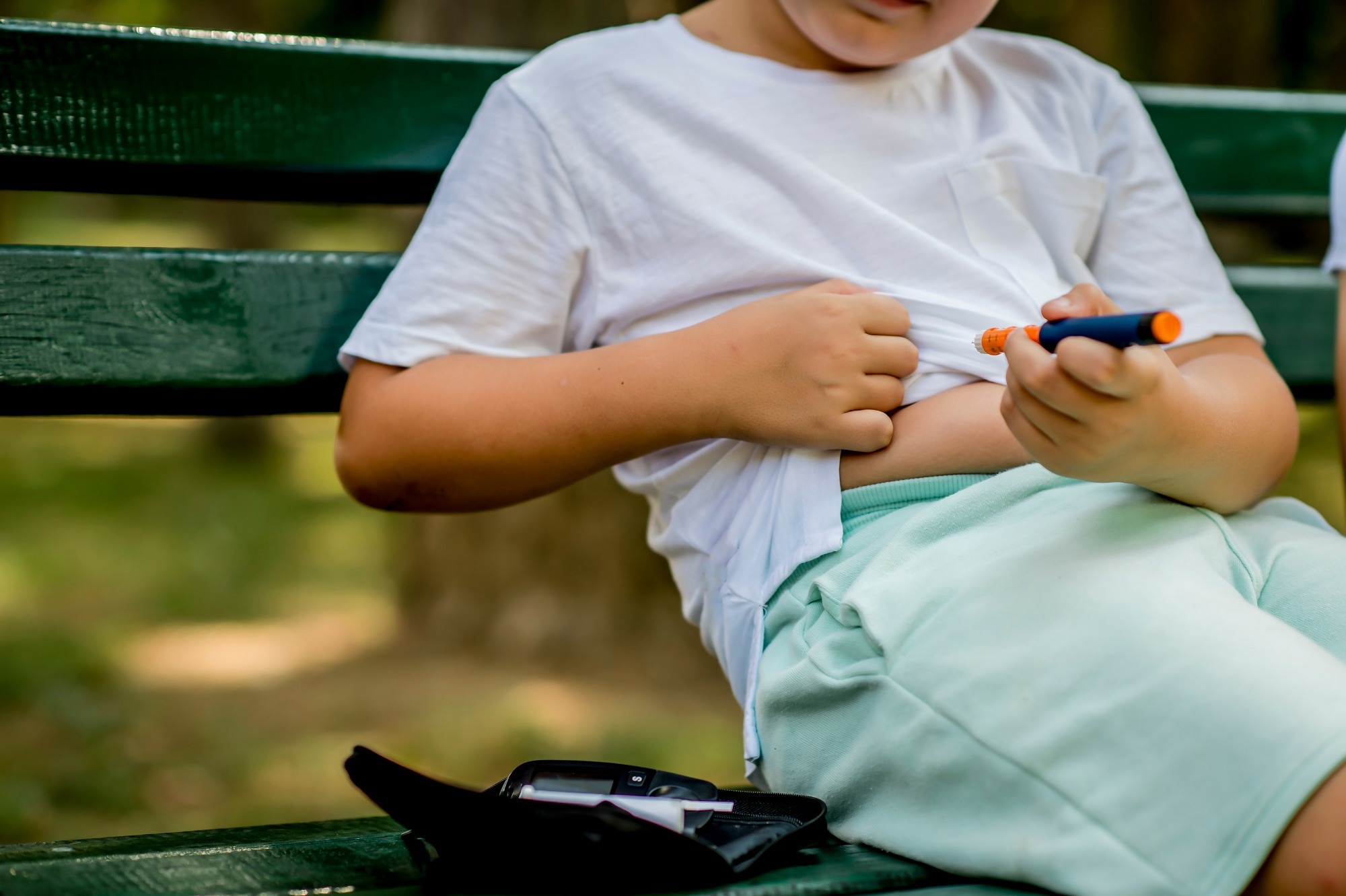 School boy with diabetes injecting insulin