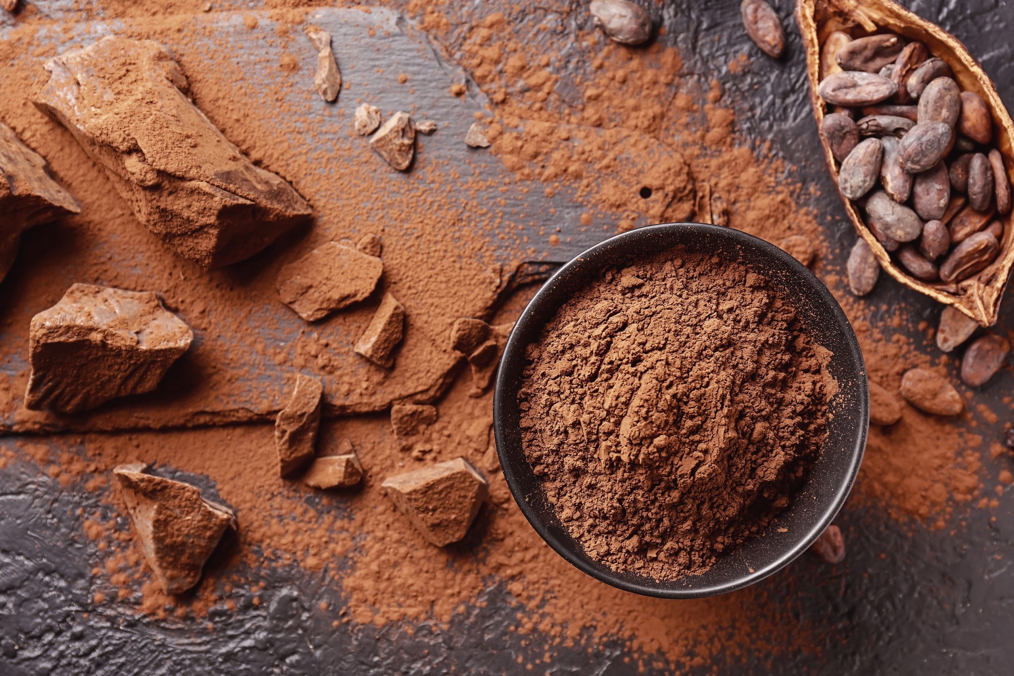 cocoa powder and beans on a black background