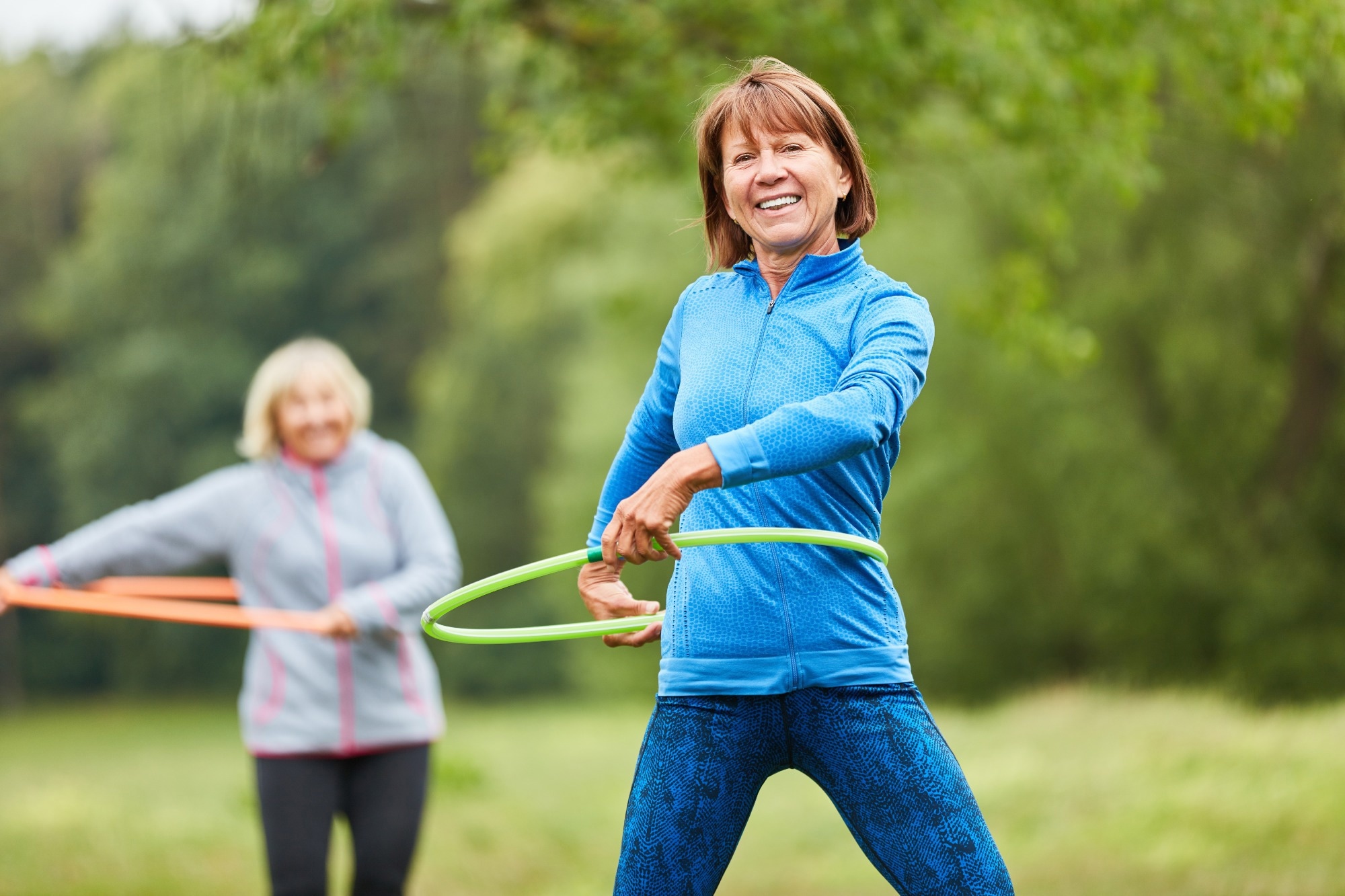 Senior women are doing exercise with hoop for fitness and coordination